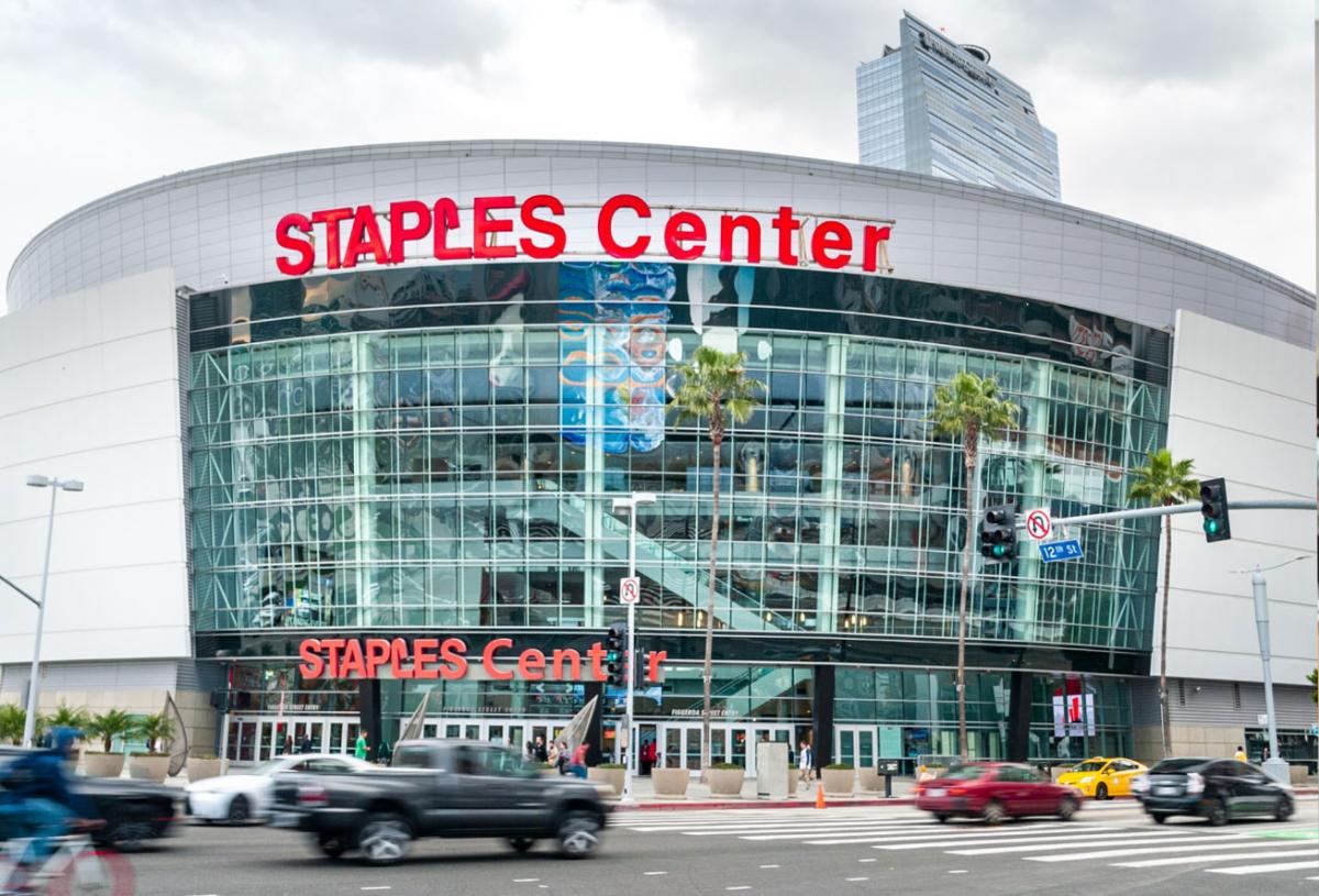 An outside view of Staples Center with vehicular traffic passing by.